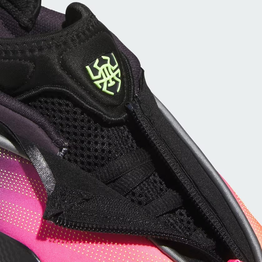 Close-up of a black and pink sneaker with a logo on a light gray background