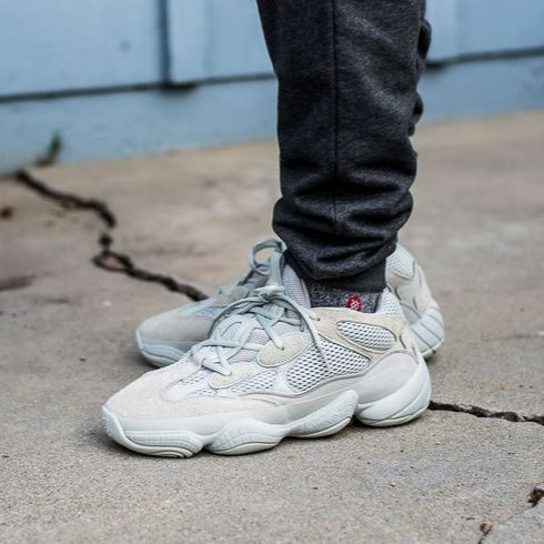 Men's Adidas Yeezy 500 - Stone Salt on a concrete surface with a blurred background