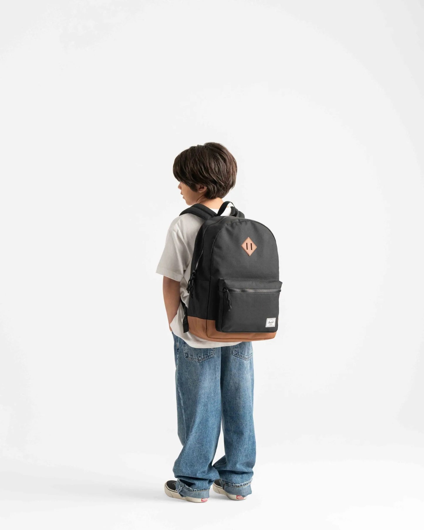 Child wearing a black backpack with a logo on a white background