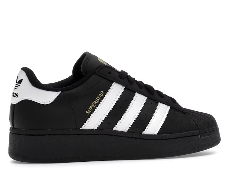 Black Adidas Superstar sneaker with white stripes on a white background