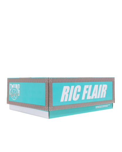 A turquoise and white box with gray trim, featuring the text 'RIC FLAIR' and a circular logo on the side, photographed on a plain white background.