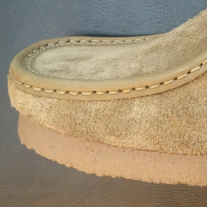Brown suede shoe on a dark surface