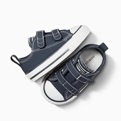 A pair of navy blue canvas toddler sneakers with white rubber soles and double hook-and-loop straps, photographed on a clean white background.