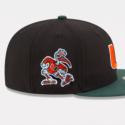 A black structured baseball cap featuring an embroidered Miami Hurricanes mascot patch on the front and a green flat brim, shown against a light gray background.