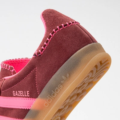 Maroon Adidas Gazelle sneaker with pink accents on a light gray background