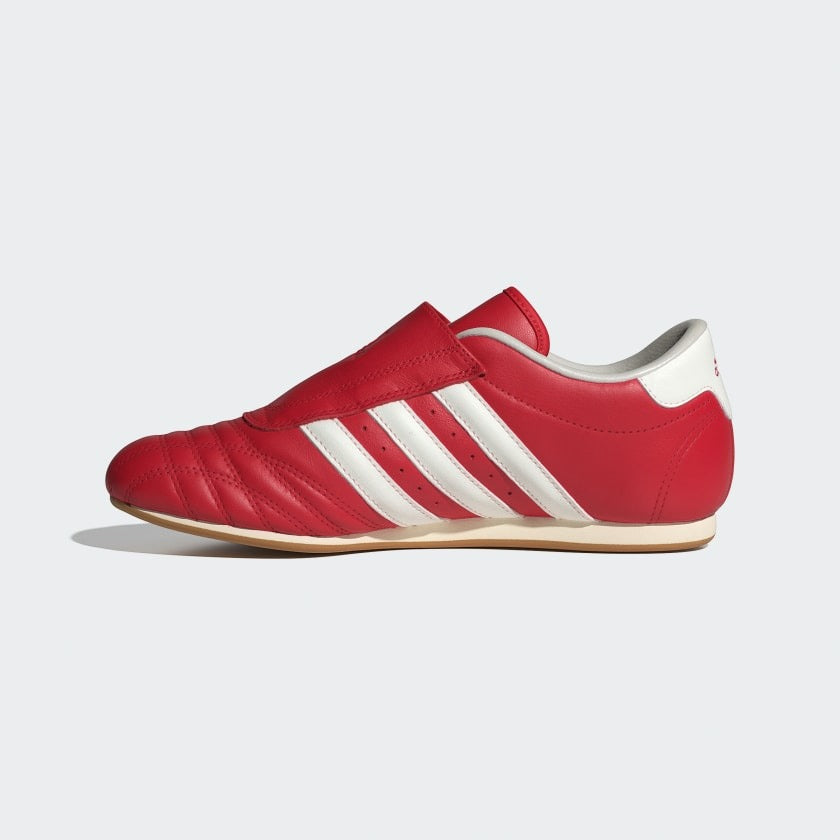 Red Adidas shoes with white stripes on a light gray background