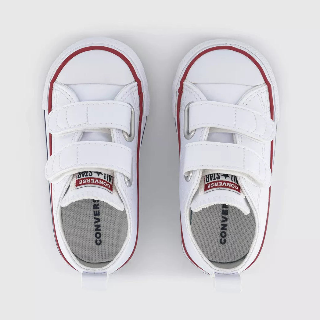 A pair of white Converse Kids platform sneakers with hook-and-loop straps, featuring red piping and a gray Converse Kids insole, shown from a top-down view on a light gray background.